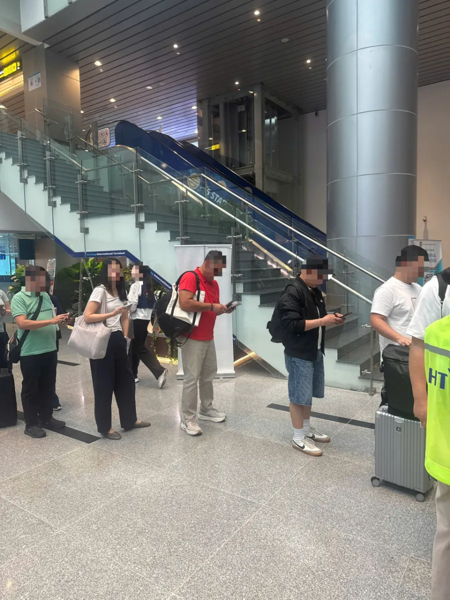다낭공항 입국장 에스컬레이터 앞에서 입국 심사를 기다리는 승객들