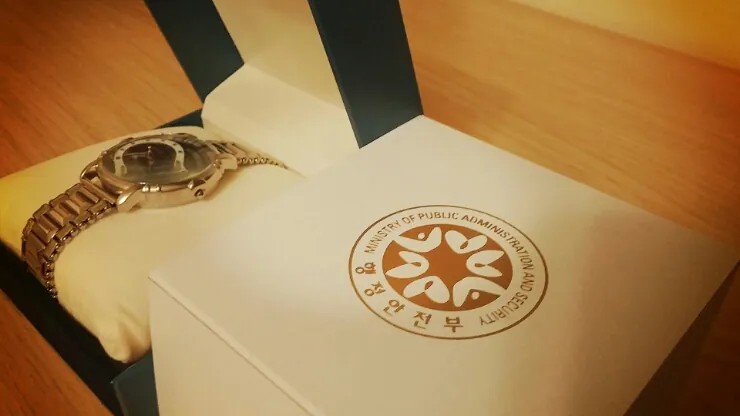 손목시계와 정부 문양이 찍힌 상자