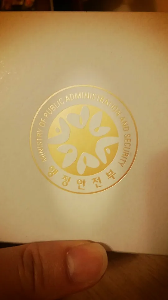 정부 문양이 찍힌 봉투를 든 손