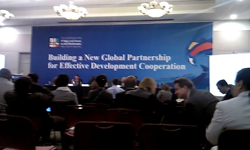 대형 행사장과 파란 배경막(영문 글자 'Building a New Global Partnership for Effective Development Cooperation')